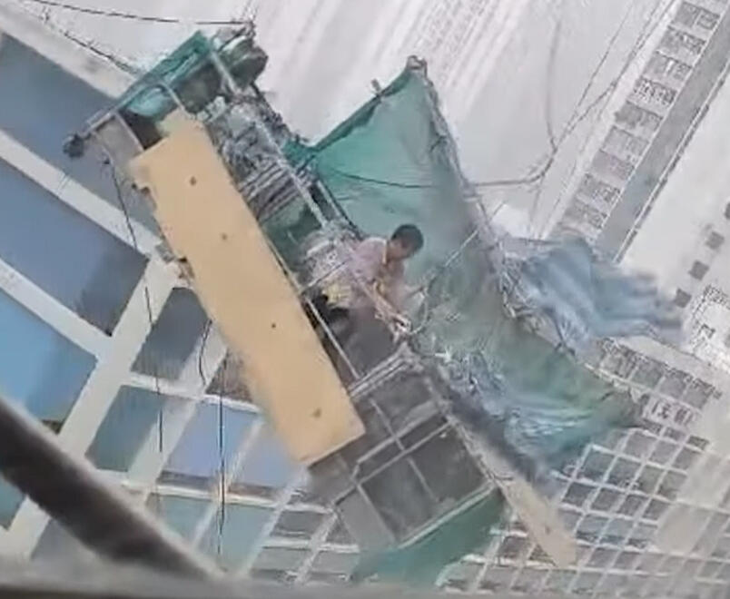 Technician cleaning building exterior in Hong Kong without scaffolding.